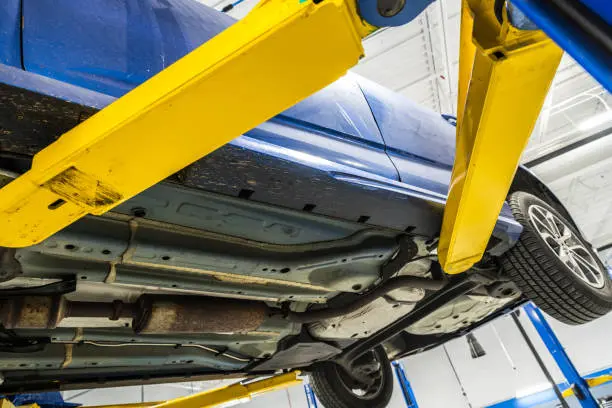 Damaged car underbody inspection at an auto body shop